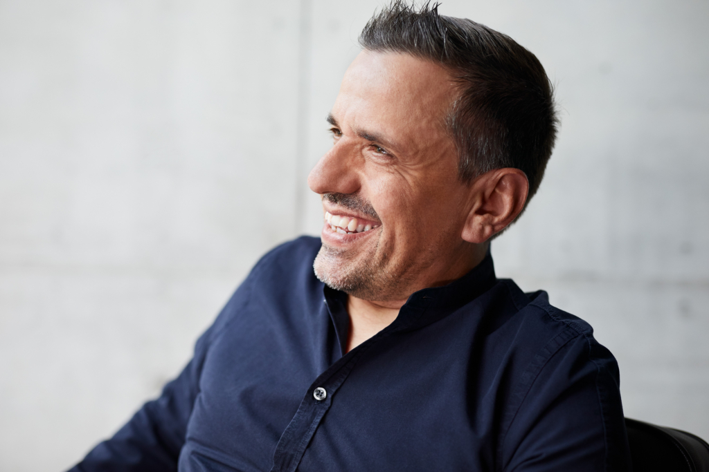 Raphael Gielgen, Zukunftsforscher und Trendscout bei Vitra, mit Porsches Mission-E Prototyp