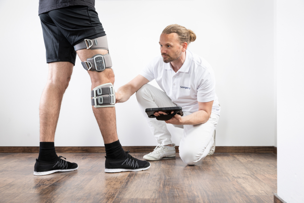 Seeger Gesundheitshaus und Orthopädietechnik, Bilder von Mitarbeitern und Mitarbeiterinnen in den Werkstätten: Anprobe einer Orthese am Bein