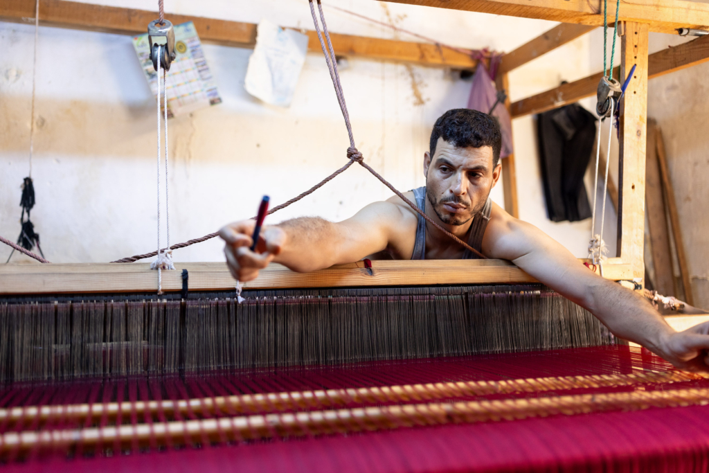 Fez, Morocco, has a long tradition of arts and crafts. I visited and photographed artisans from a variety of fields in their workshops. Weaver at a traditional loom.